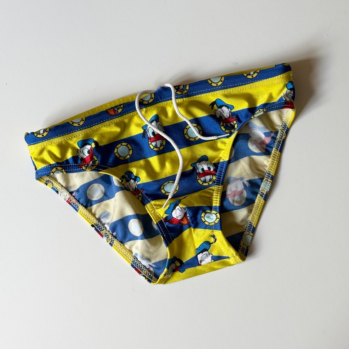 Disney Donald Duck boys yellow and blue striped swim briefs. Size 8 years